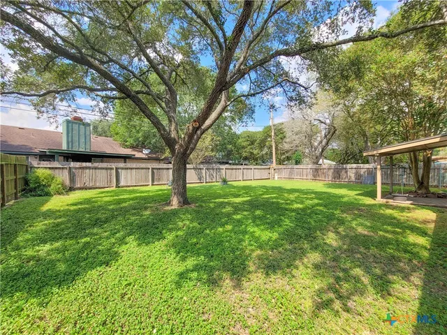 a view of yard with green space and house in the background