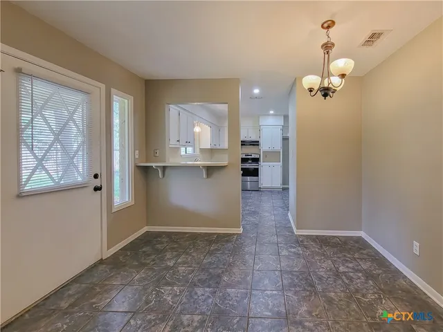 a view of a kitchen with a dishwasher cabinets and a window