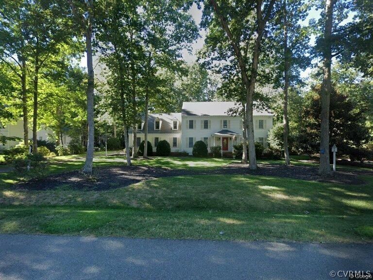 a view of a house with a big yard and large trees