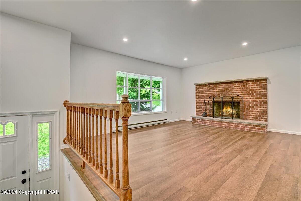 6051 Neola Road Stroudsburg, PA 18360 - Photo 3 of 57 an empty room with wooden floor fireplace and windows