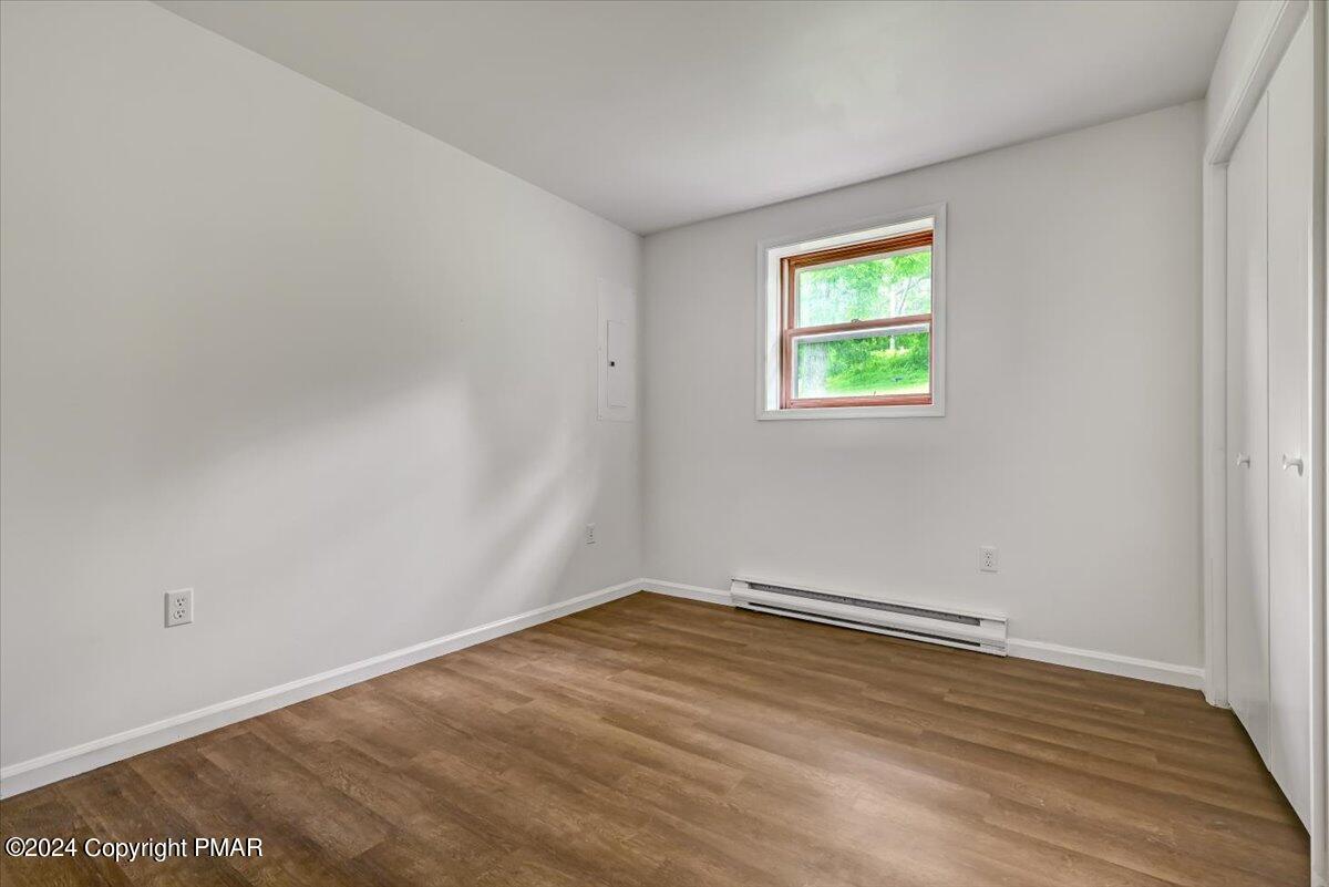 6051 Neola Road Stroudsburg, PA 18360 - Photo 34 of 57 an empty room with wooden floor and windows