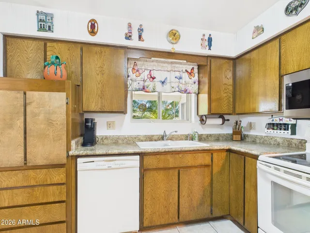 a view of house with a yard and potted plants