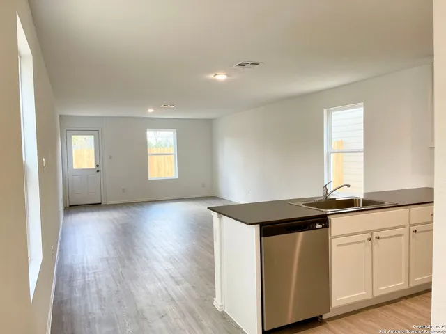 a kitchen with granite countertop a sink and dishwasher with wooden floor