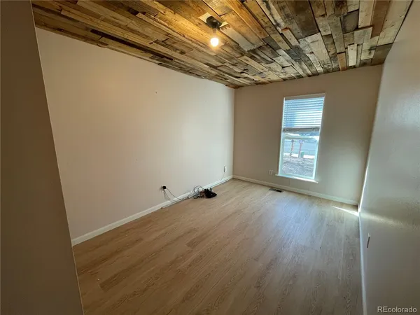 a view of empty room with wooden floor