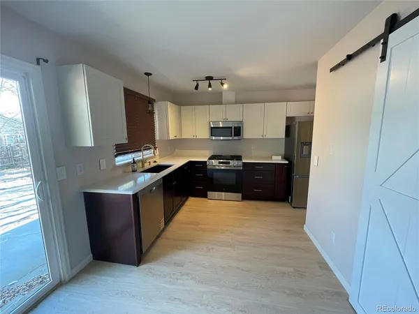 a kitchen with stainless steel appliances a refrigerator and a stove top oven