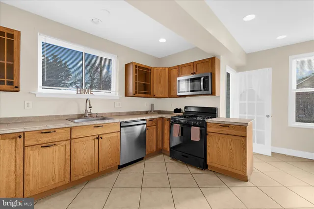 a kitchen with stainless steel appliances granite countertop a stove top oven sink and cabinets