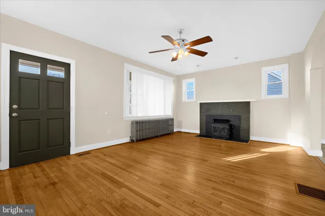 a view of an empty room with a window and fireplace