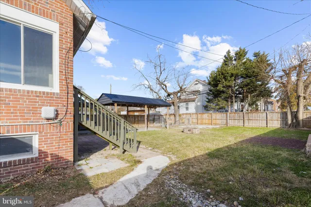 a front view of a house with a yard and table and chair under an umbrella