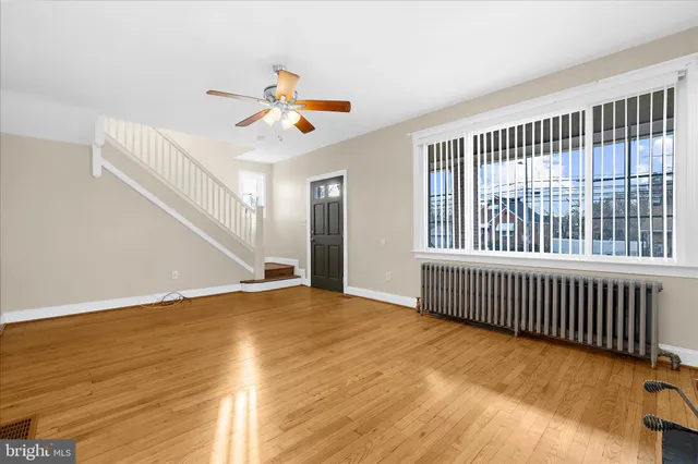 a view of a livingroom with wooden floor and a ceiling fan