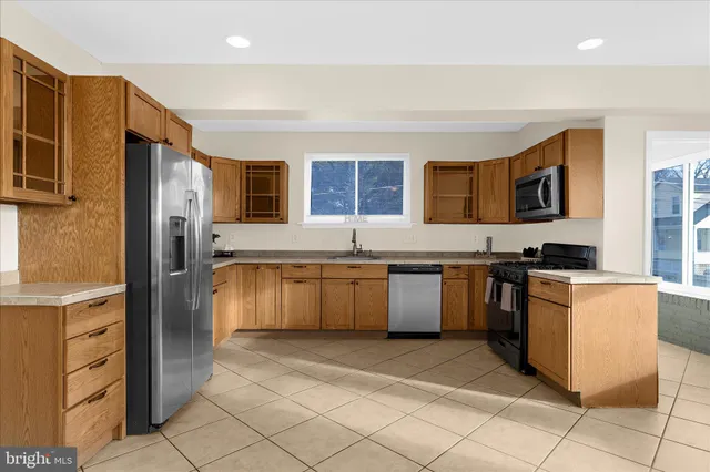 a kitchen with stainless steel appliances granite countertop a refrigerator and a stove top oven