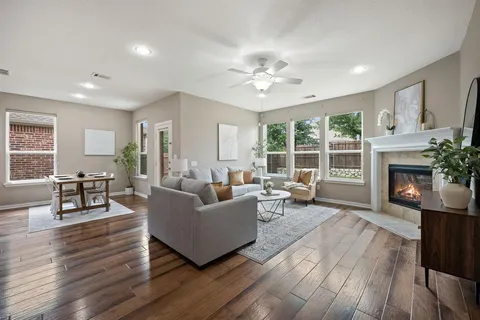 a living room with furniture dining table a fireplace and a window