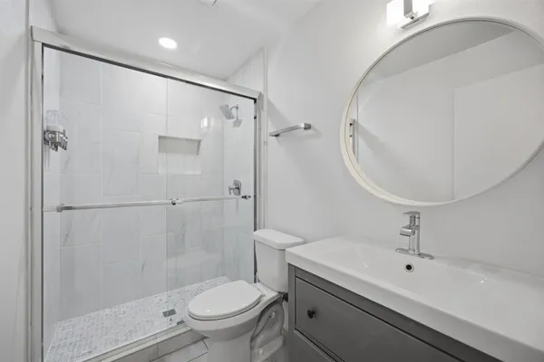 a bathroom with a sink a toilet and shower