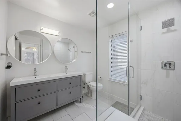 a bathroom with a double vanity sink mirror and shower