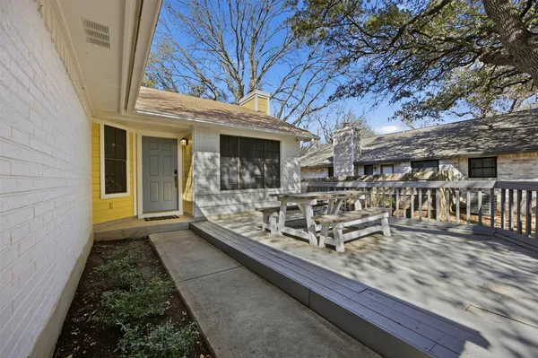a view of a house with wooden deck and furniture