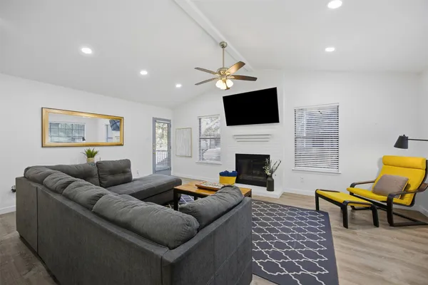 a living room with furniture a fireplace and a flat screen tv