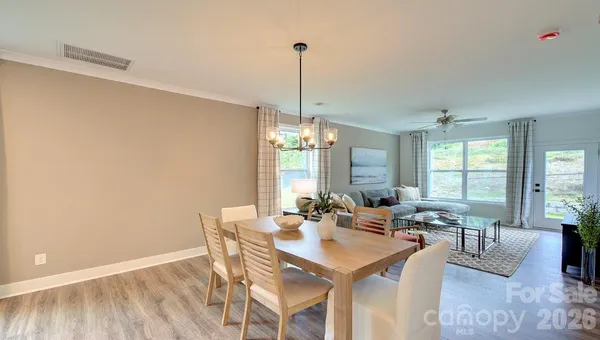 a view of a a dining room with furniture window and wooden floor