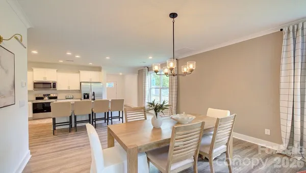 a view of a dining room with furniture wooden floor and chandelier
