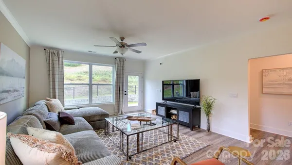 a living room with furniture a flat screen tv and a window