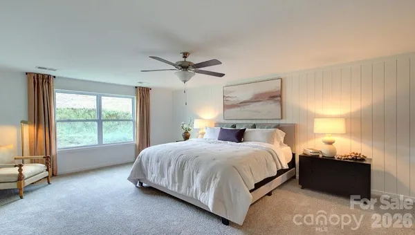 a bedroom with a bed and a large window