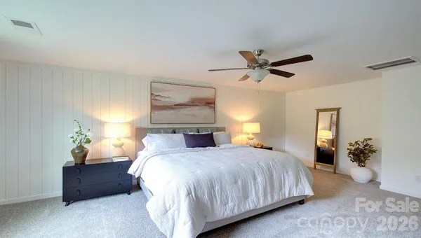 a bedroom with bed and a chandelier