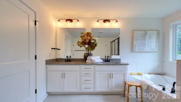 a spacious bathroom with a granite countertop sink and a mirror