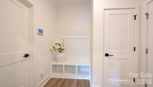 a view of a hallway with wooden floor and closet