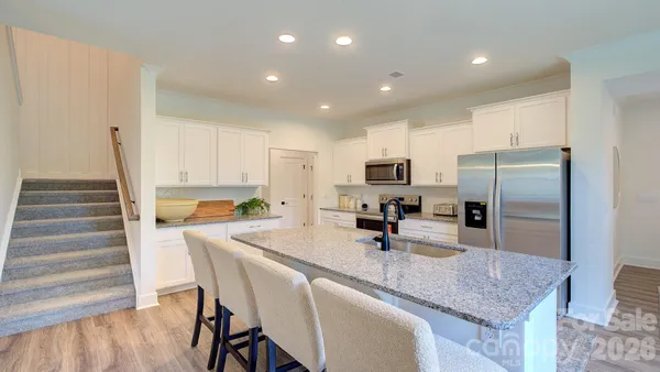 a kitchen with kitchen island a counter top space appliances and cabinets