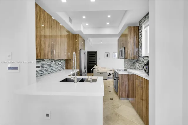 a kitchen with stainless steel appliances kitchen island granite countertop a table chairs in it and wooden floors
