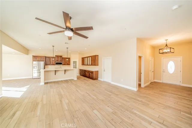 a view of a kitchen with wooden floor a sink a refrigerator and window