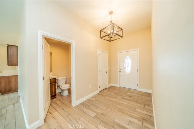 a view of a hallway with wooden floor and chandelier