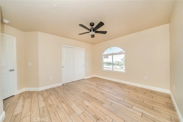 a view of a room with wooden floor and a ceiling fan