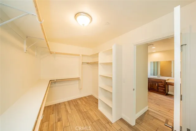 a view of a room with wooden floor and a ceiling fan