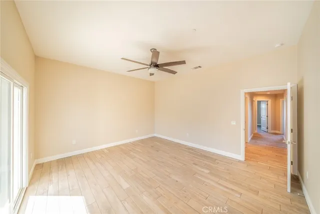 a view of a room with wooden floor and a ceiling fan