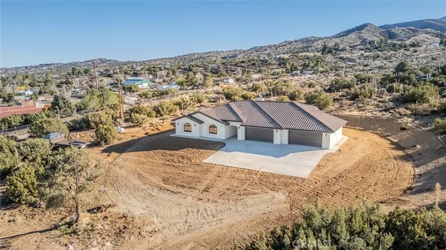 an aerial view of a house with a mountain