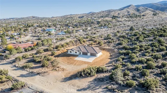 an aerial view of house with yard and mountain view in back