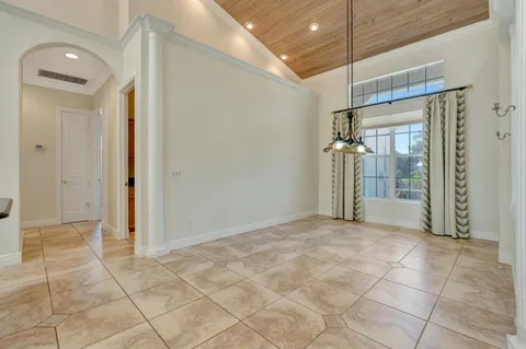 a view of a hallway with granite countertop a sink and white cabinets