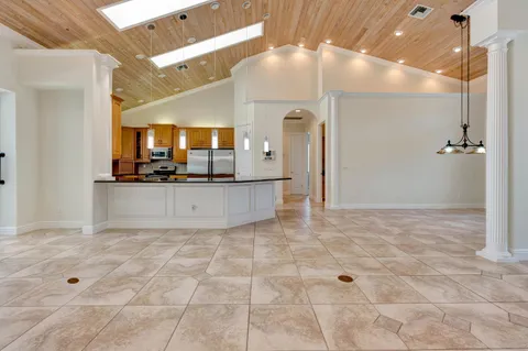 a kitchen with granite countertop a refrigerator and white cabinets