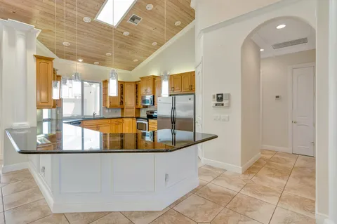 a large kitchen with stainless steel appliances granite countertop a refrigerator and a sink