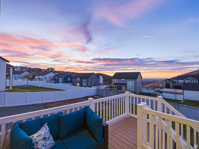 2487 Canyon Wild Road, Unit 413 Draper, UT 84020 - Photo 70 of 75 Deck at dusk with a residential view and a fenced backyard