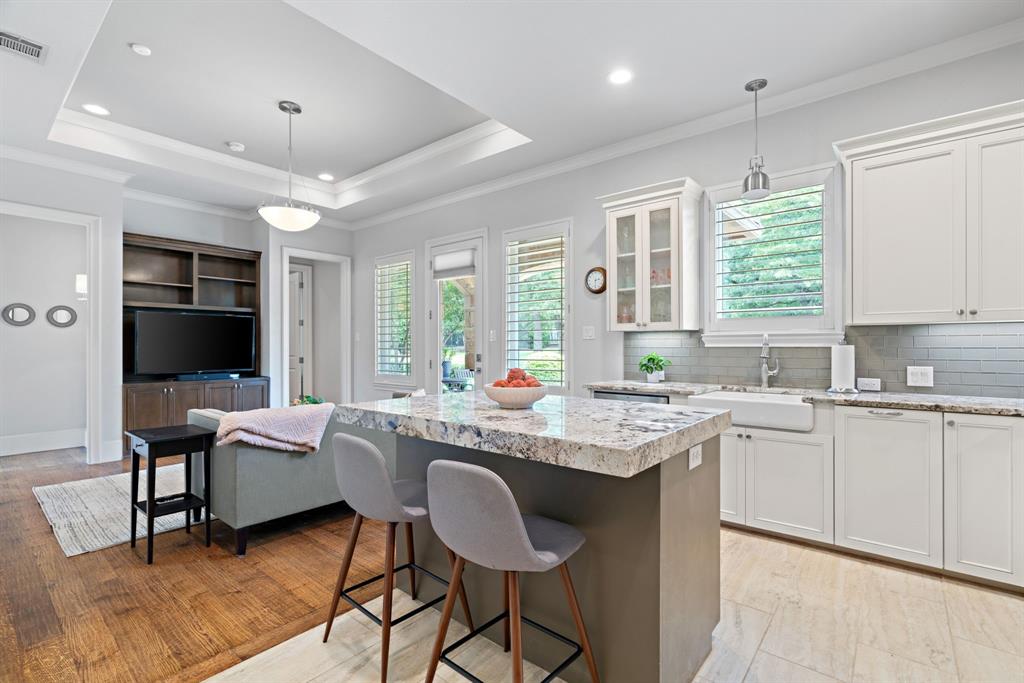 1908 Point De Vue Flower Mound, TX 75022 - Photo 29 of 40 a open kitchen with stainless steel appliances granite countertop a stove a refrigerator a sink dishwasher a dining table and chairs with wooden floor