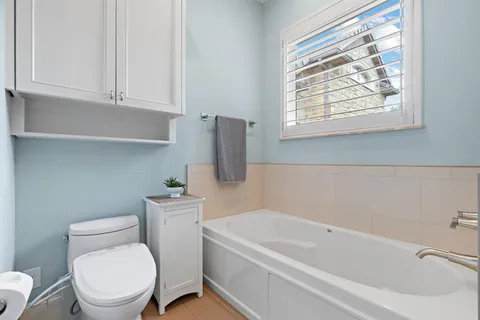 a white toilet sitting next to a bath tub