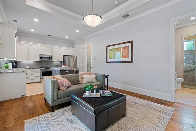 a living room with furniture kitchen and a chandelier