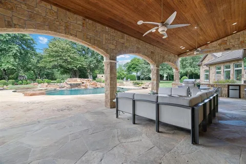 a view of a patio with a table chairs and a floor to ceiling window