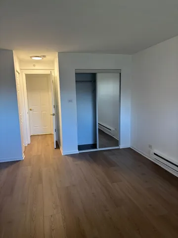 an empty room with wooden floor and closet