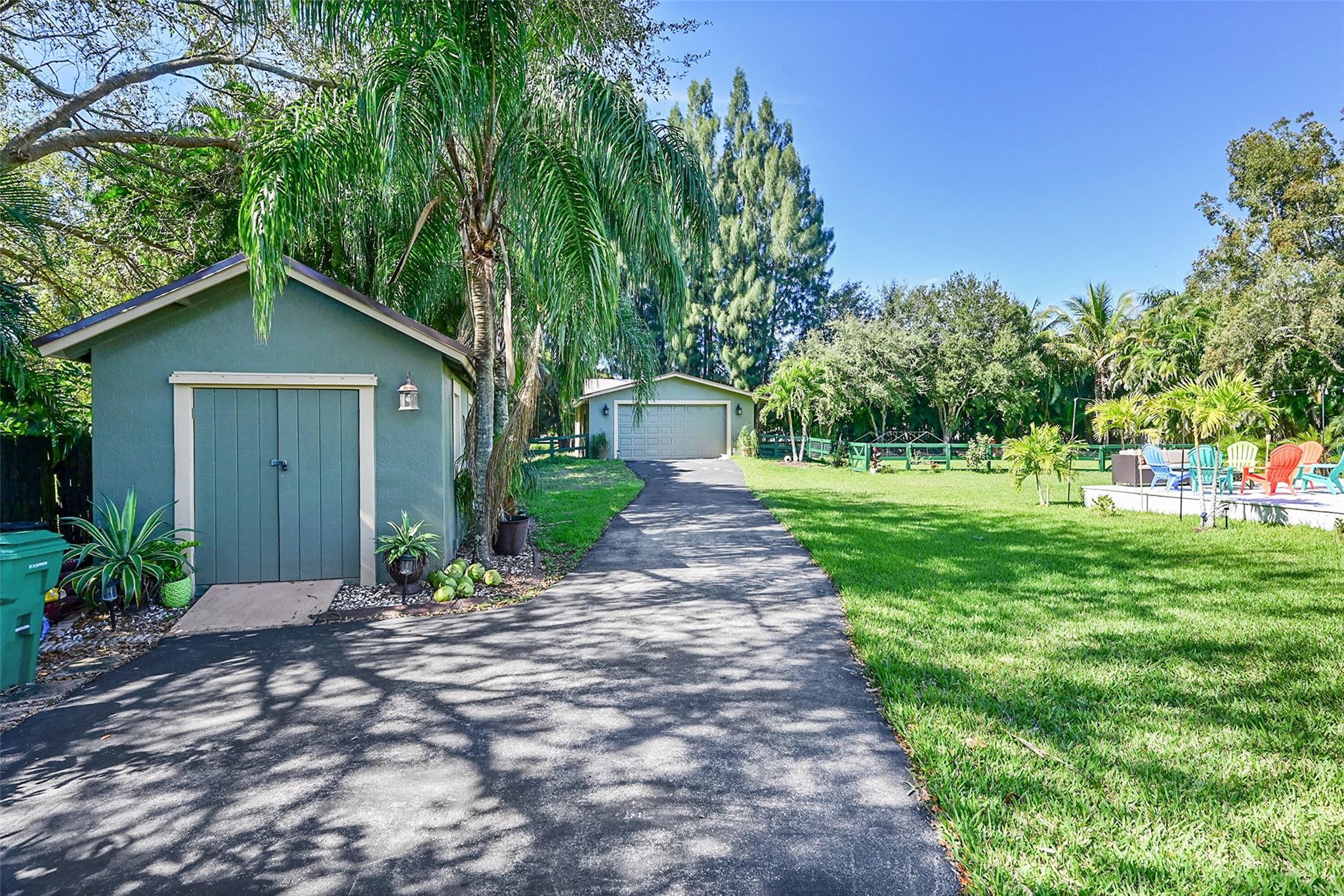 Undisclosed Address Southwest Ranches, FL 33331 - Photo 10 of 24 a front view of a house with a yard and potted plants