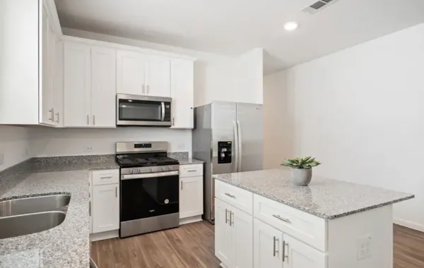a kitchen with stainless steel appliances granite countertop a sink stove and refrigerator