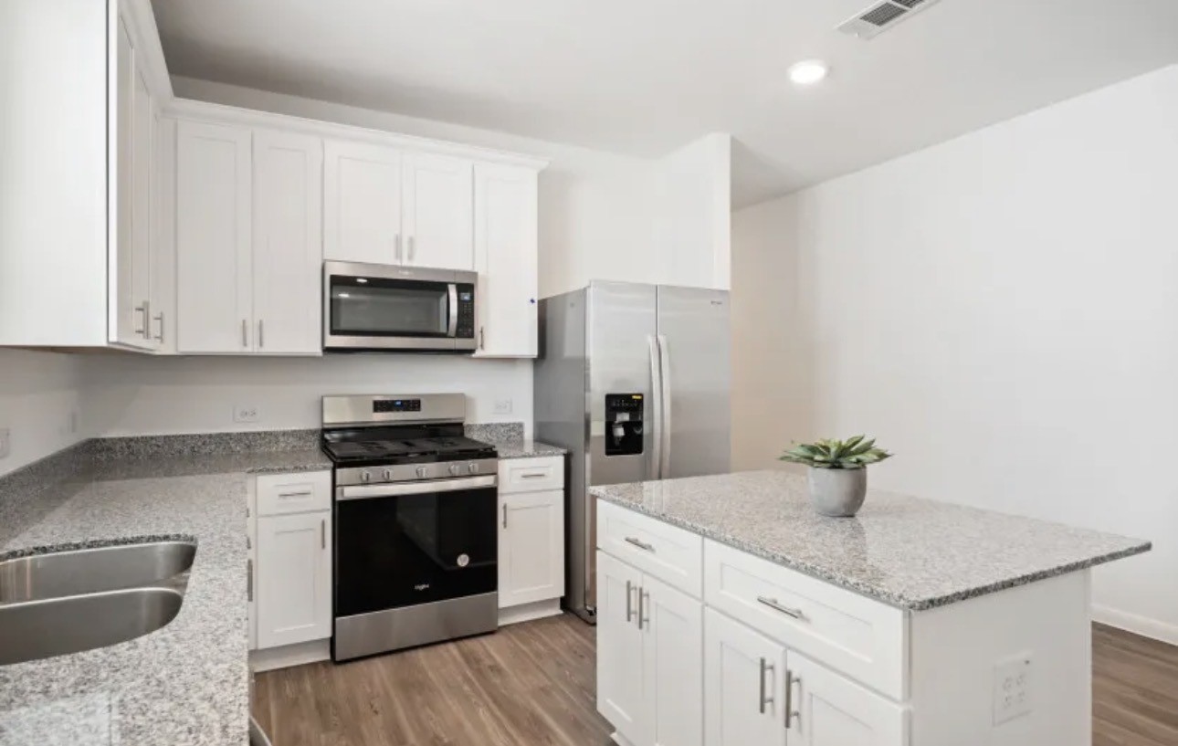 248 Seven Pines Willis, TX 77378 - Photo 3 of 17 a kitchen with stainless steel appliances granite countertop a sink stove and refrigerator