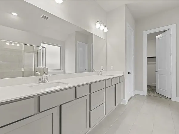 a bathroom with double sink and a mirror