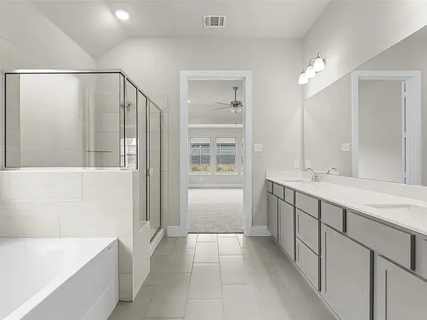a bathroom with a tub a sink and mirror