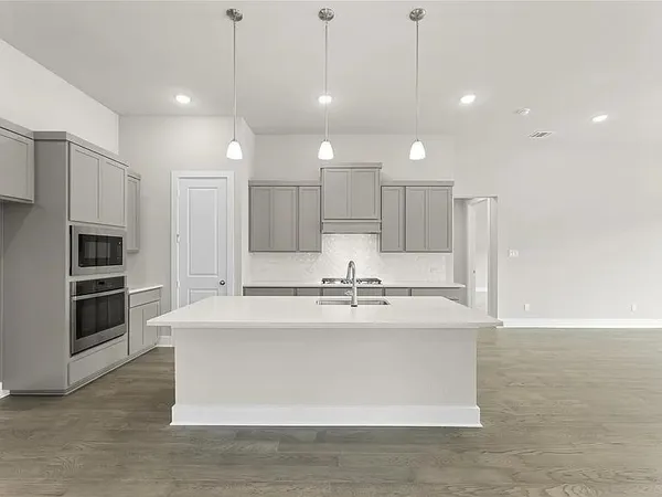 a large kitchen with kitchen island a counter top stainless steel appliances and cabinets